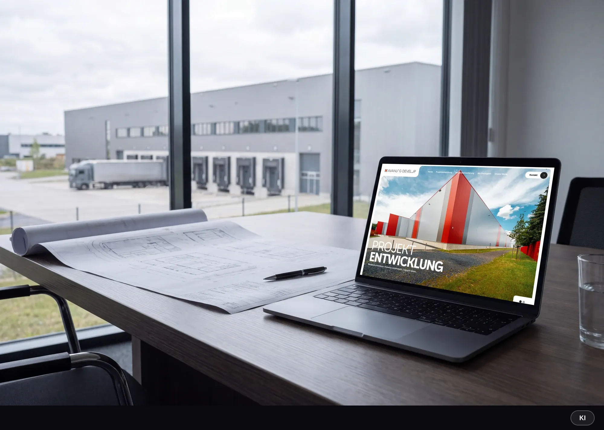 KI-generiertes Bild: Laptop mit der Startseite von AvanLog Develop auf einem Konferenztisch neben ausgerollten Bauplänen, im Hintergrund eine Logistikhalle mit Ladetoren