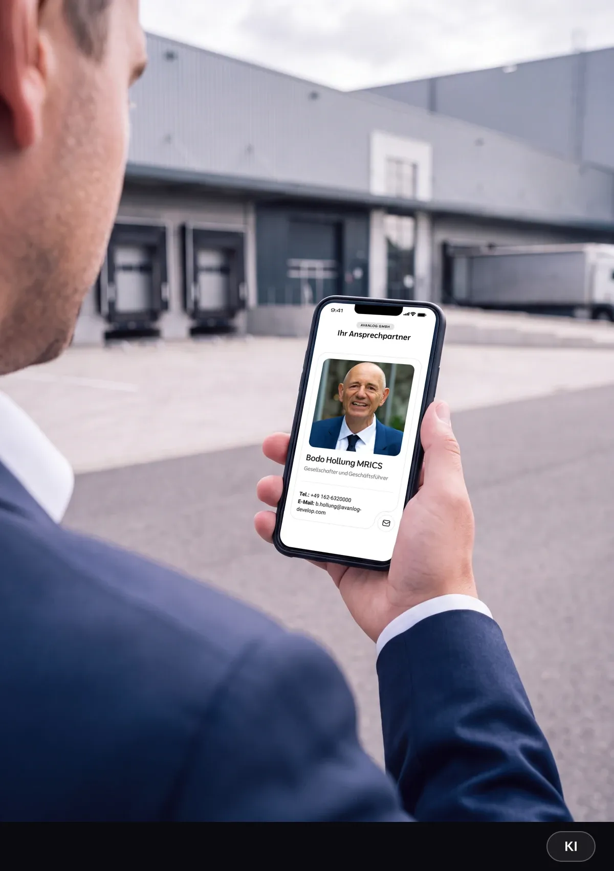 KI-generiertes Bild: Investor im dunklen Anzug hält ein Smartphone mit dem Ansprechpartner-Bereich der AvanLog-Website vor einer Logistikhalle