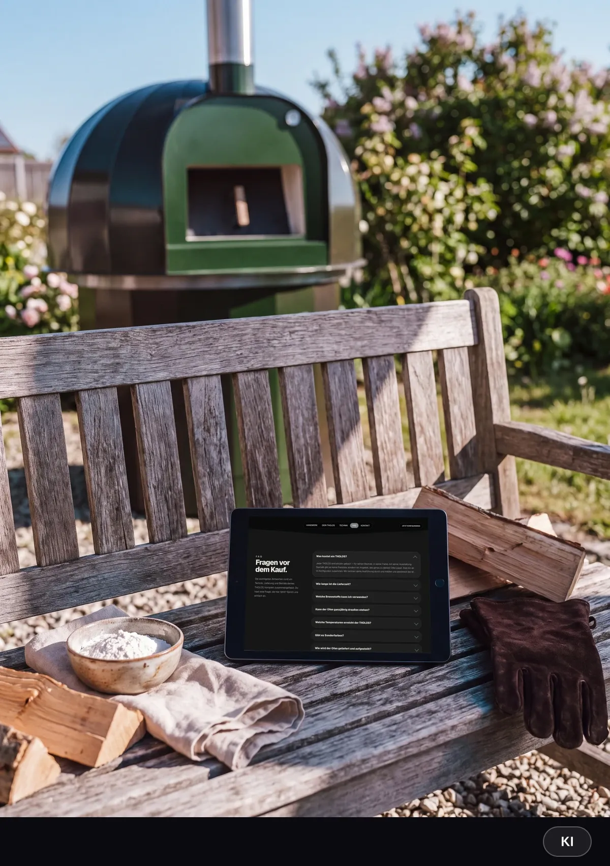 KI-generiertes Bild: Tablet mit den häufigen Fragen vor dem Kauf auf einer Holzbank, daneben Brennholz, Mehl und Ofenhandschuhe, im Hintergrund der grüne Outdoor-Ofen