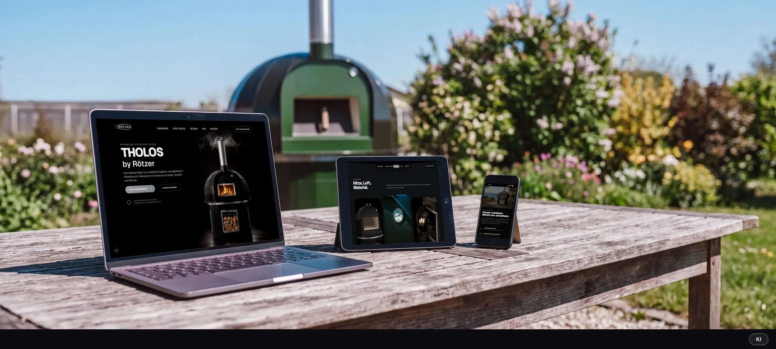 KI-generiertes Bild: Laptop mit der THOLOS-Startseite, Tablet mit dem Technik-Bereich und Smartphone mit dem Showroom-Kontakt auf einem Gartentisch vor dem grünen Ofen